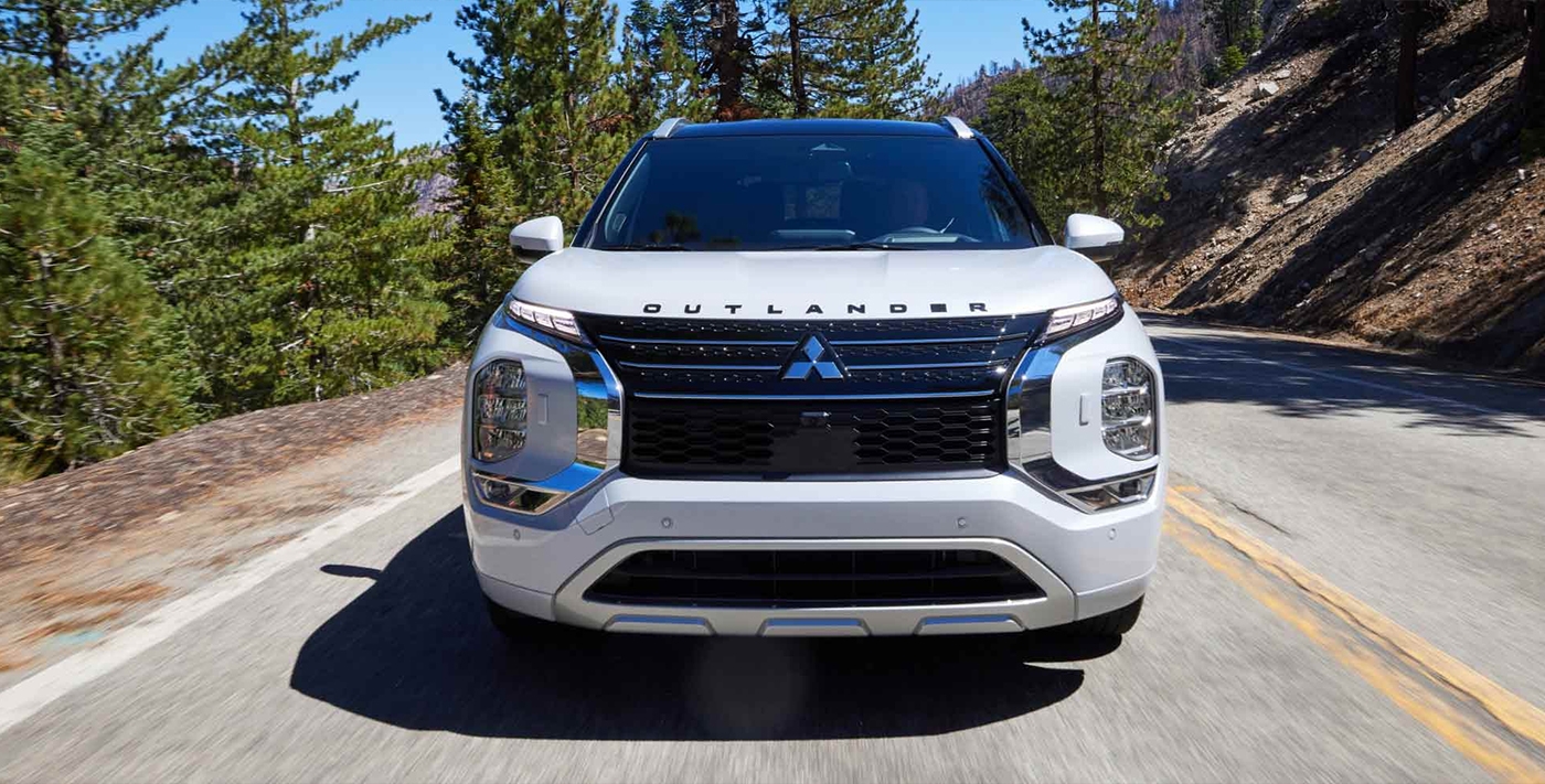 Vue avant du Mitsubishi Outlander 2025 hybride rechargeable sur route en pleine puissance..